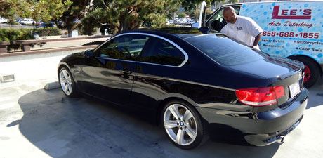 Lee detailing a black BMW beside his van